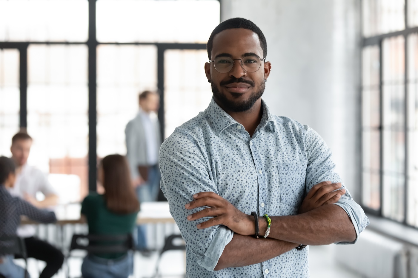 Head shot portrait confident young African American businessman wearing glasses looking at camera, successful executive startup founder standing in modern office room with arms crossed SSUCv3H4sIAAAAAAAACmxSTW/UMBD9K8U3pDWKHSex98y/aKrKX9kNTeIocaBVtVLLFSQ4Ig6V4I5URJEqqvIbnH/EONuqAnGINfP85o3nTc6RkmOt0foc1U0zjX6QvnYdWicrNNjO2GEJram9G2rZLJmSXm872Vq07qam2a3Q6KWfRjuCDmRaersB+pI/Njg8jzhaIwT0ScVgt/oPdrRCcmM7fRZrzWBlO/o6tjpERQa8QsBBKEVHO2g12MbKpfEhqlhWJDaxOCG5xSwhCZYkJ9jmghRMEKEUhdpccsU4sdikicZMpwWWRUpxJQqWxVIlNdCyIuVCMI0NtwlmhQE1YwTmlqdMWc5VSoBGlVFJRQRmAMJhDJYq0zhnlmTU0szkFmgqzzOSaYa1EgVmhFvM80RgqlhqeMZ5RSWC0U/eeDu0Dz7KydQu2vDaadkAmALYD7Wuu82e4fw2bghsdFPnh7O9lY1zvVQNeFZBmV2hrRxHIJgHIK4IVu3avUjnfDQwVhrYHEQkpYywIktFwnguMpKixx1vayiMjWIlhPqkNg/PrUEfUUklN5JibgqCo1GwBPBOV1pQY8C6RILY1DdOGr9MN24nD1MvYmhNVn9tHVJpnLJPt4SmQ7VEqt4scL91USlW2t6NtV8AeBUgWnb/cHrXmWx/5xo3Dcqd7ts0soW5IqM+9XKJWjc+icGIlRva5Ycd5AhPXryG1fTSbwF8uS7LZwfhS/garsLn8Kksw9V8EW7DD/juw3W4m9+VJU2I2J/HJDkG5q/57fwhfJ8v5vdlKZ4fhG/hJtzOl/Nl+B3uDyjIfAx34ScQL0HkPtyA6HVZZuTFq36Ddn8AAAD//wMAWDWV88QDAAA=